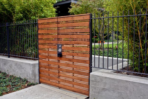 a beautiful wooden gate from an opening into a garden