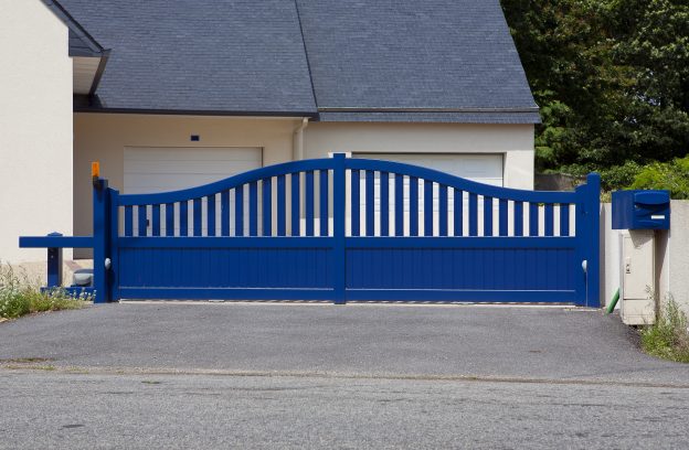 New family house with blue automatic gates in front of garage door. Picture is taken in Brittany , France and blue color is traditional. Automatic gate, also cantilever gate.